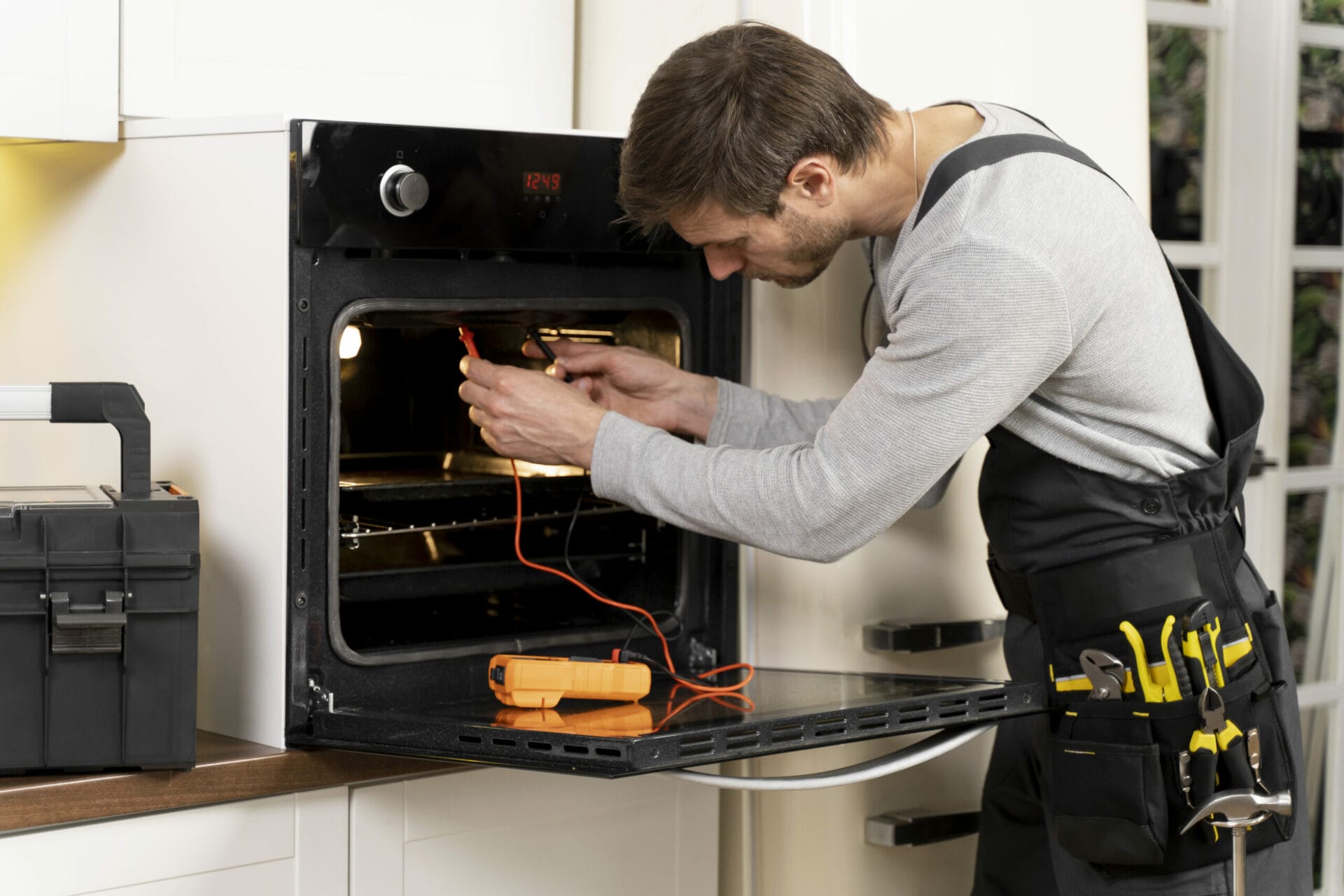 A man in Boston working in an oven for appliance repair.