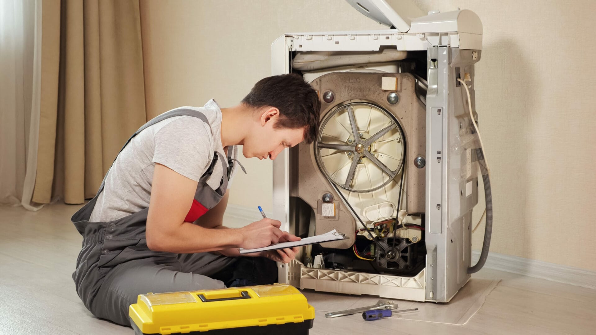 A man performing appliance repair on a refrigerator in Boston.