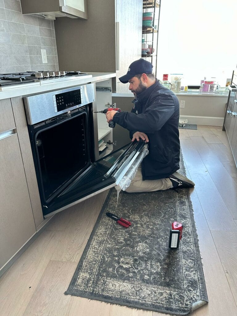 Technician repairing a oven in a Boston home