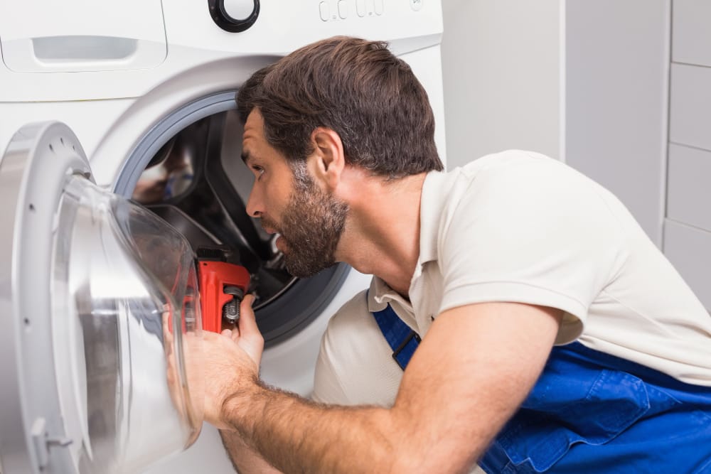 Professional appliance repair technician servicing home appliance in Malden MA kitchen